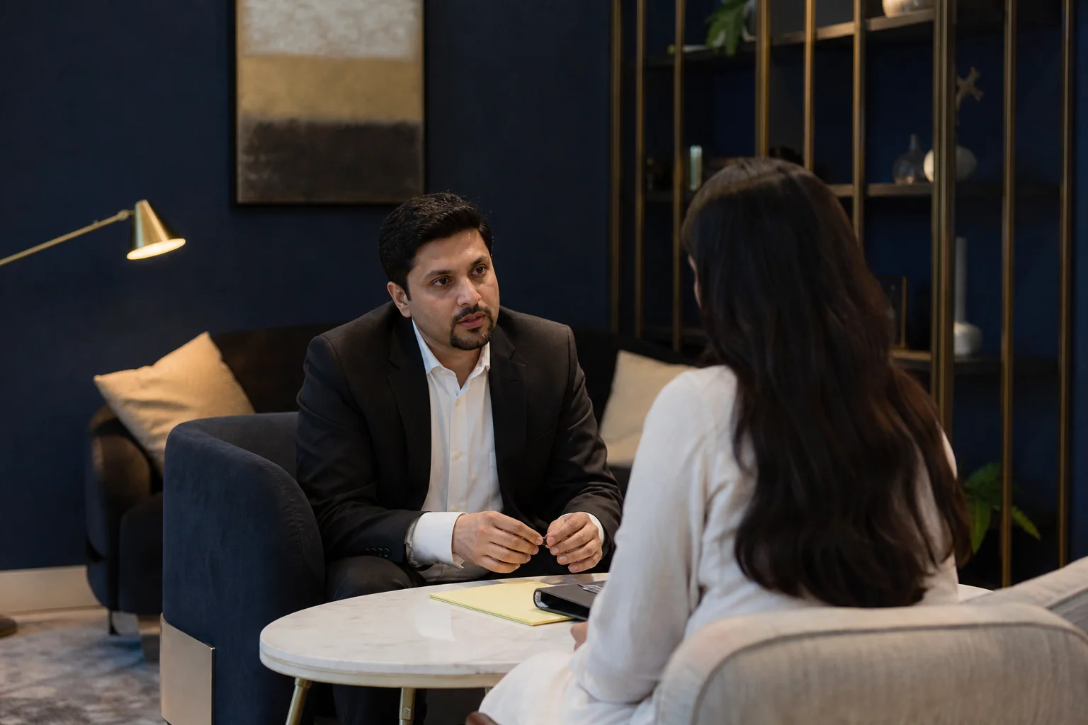 A confidential one-on-one consultation between an employee and a lawyer in a calm private setting, representing trust and discretion. photorealistic photo, a private and calm consultation room setting, an Indian lawyer in professional