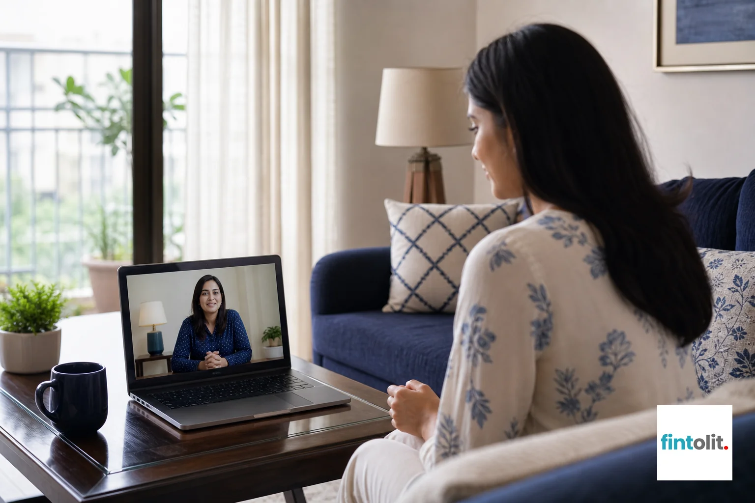 photorealistic photo of an Indian woman having a relaxed video call consultation on a laptop from her living room in Delhi NCR, screen showing a professional-looking consultant, soft natural daylight, indigo and white color palette in the