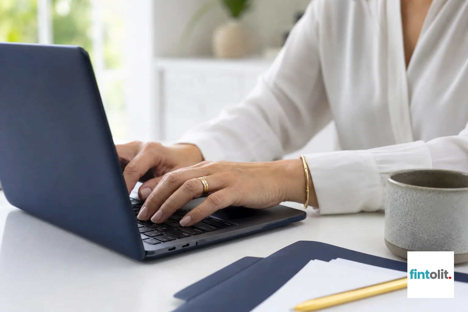 Close-up of hands typing on laptop filing an online complaint form. photorealistic close-up photo of hands typing on a laptop keyboard at a bright home office desk, a coffee cup and a folder of documents nearby, soft natural lighting, calm