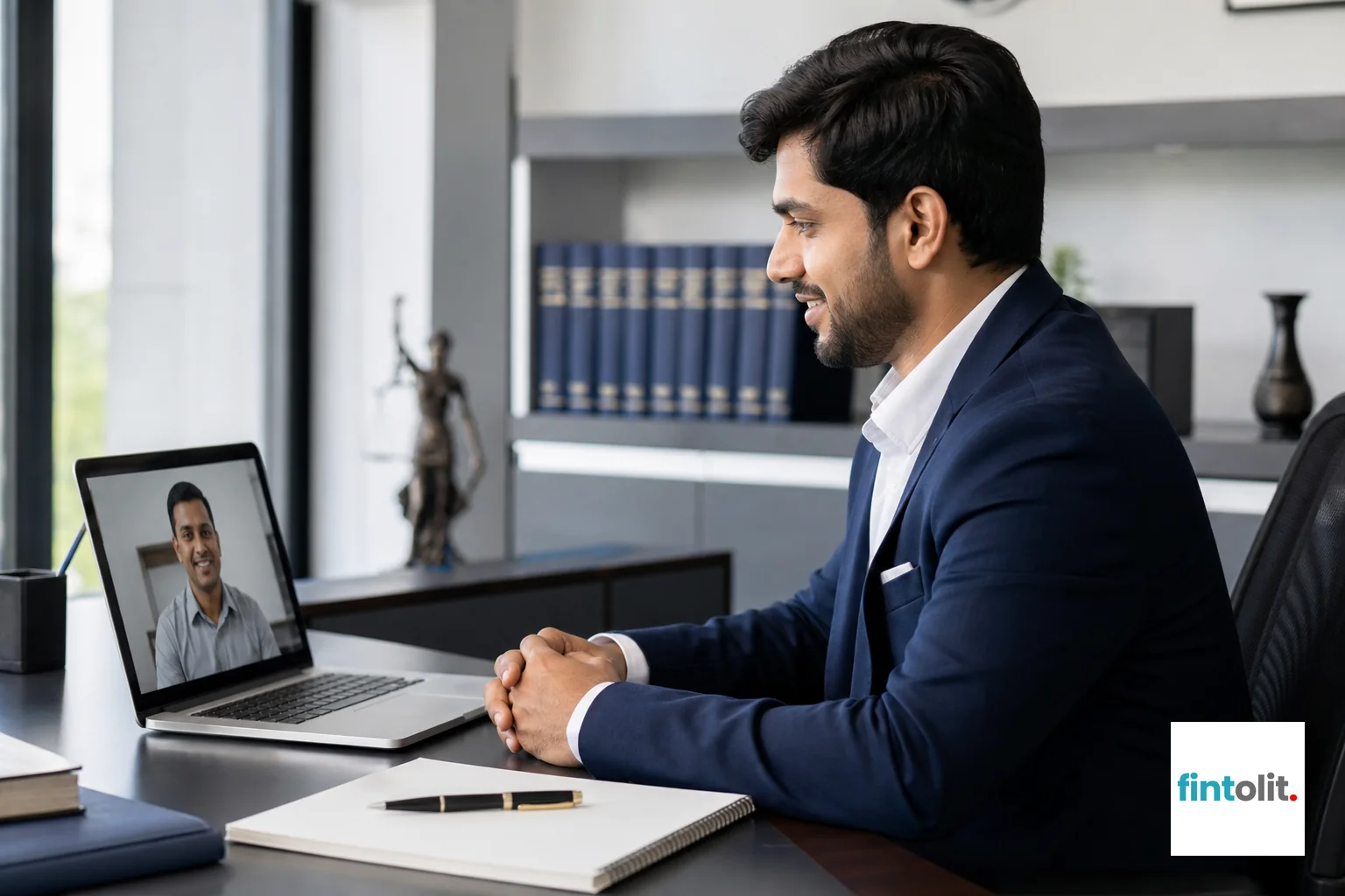 Photorealistic photograph of an Indian legal professional in business attire sitting in a bright modern office, video calling on a laptop with a client visible on screen, notepad and pen on the desk, indigo and white color palette in office