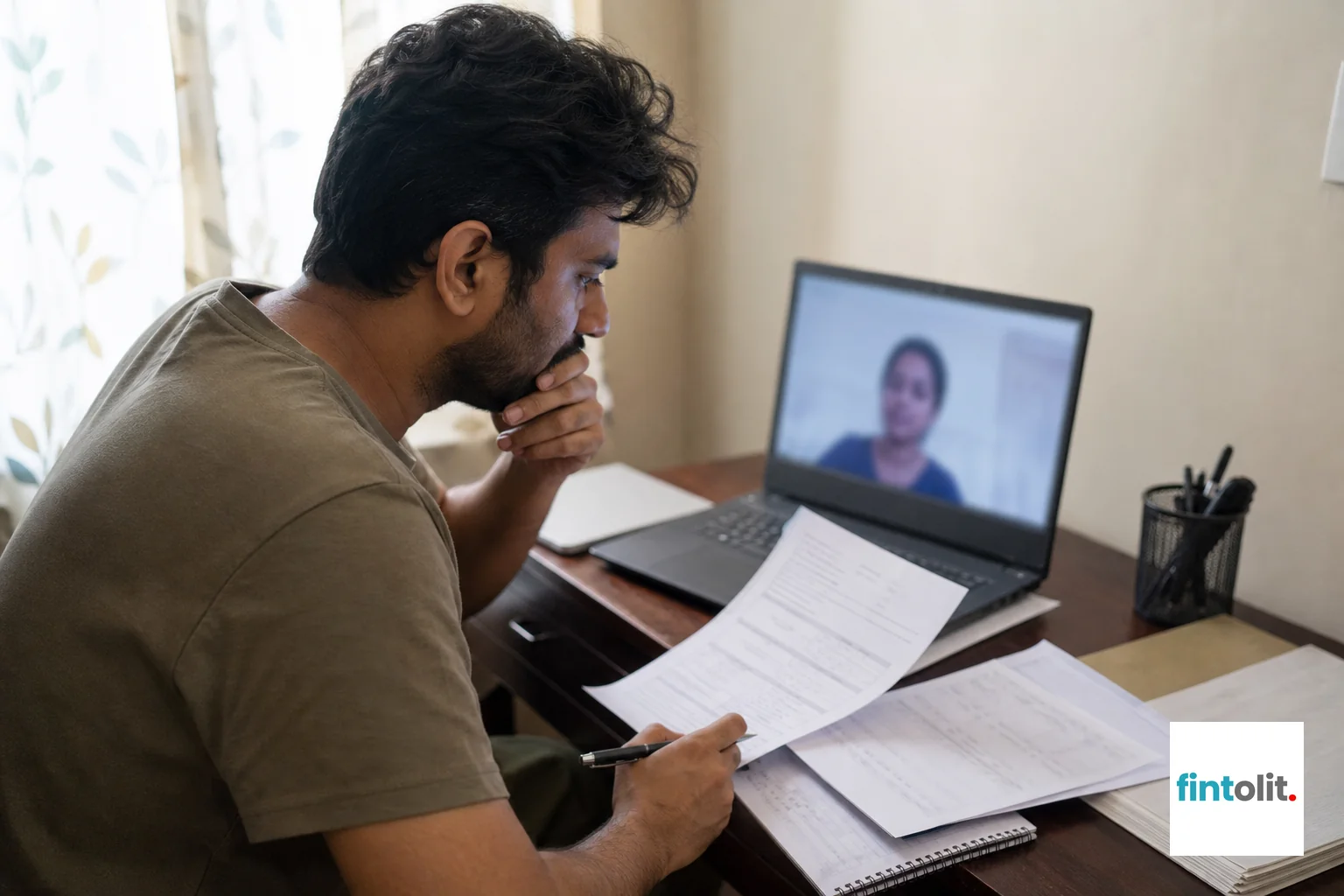 Tenant reviewing rent agreement documents at home during a video legal consultation. Photograph a person of Indian appearance sitting in a video call at home, laptop screen visible but not readable, with rent agreement papers and notes